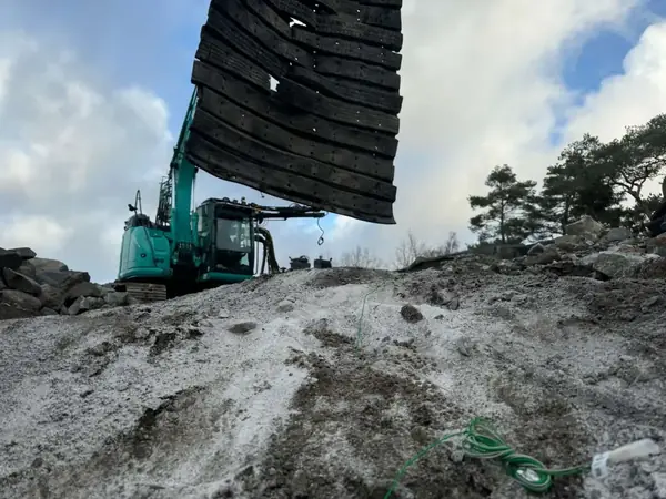 Grävmaskin på höjd under markarbete i norra Bohuslän