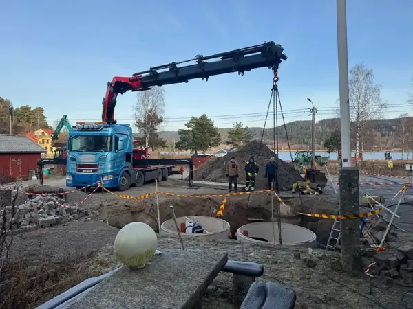 Kranbil och betongbrunnar på arbetsplats